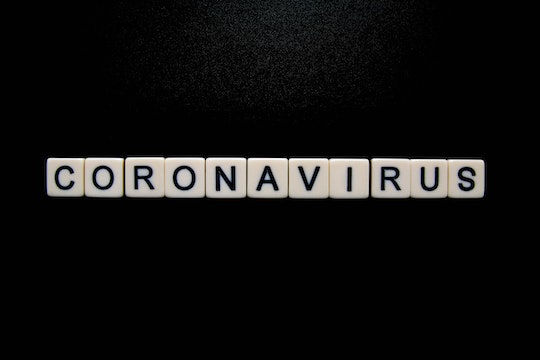 scrabble tiles on black background spelling coronavirus