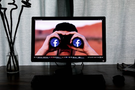 a computer screen background showing a person peering through binoculars with the facebook logo on the ends of them