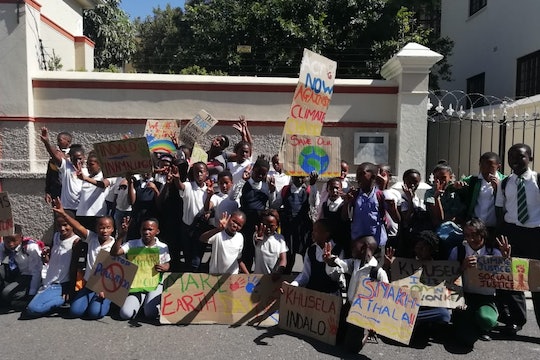 A group of young climate strikers gather with signs in Cape Town, South Africa.