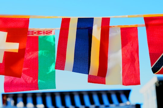 six different countries' flags hanging against a blue sky